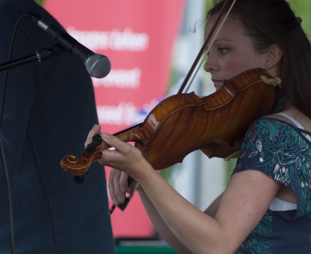 Violinist playing at Burnham Station music festival as part of Station to Station Queen's Celebration